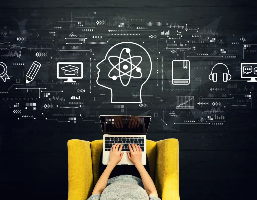 Person using a laptop in a yellow chair with e-learning icons floating above on a dark background