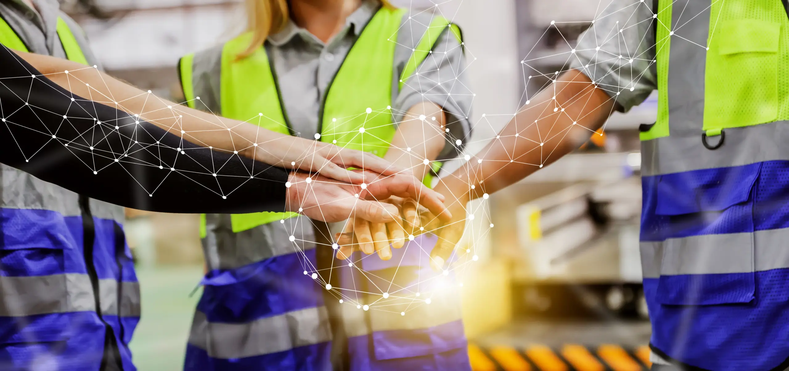 Teamwork among factory workers in safety vests